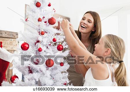 Stock Photo - Family decorating Christmas tree. Fotosearch