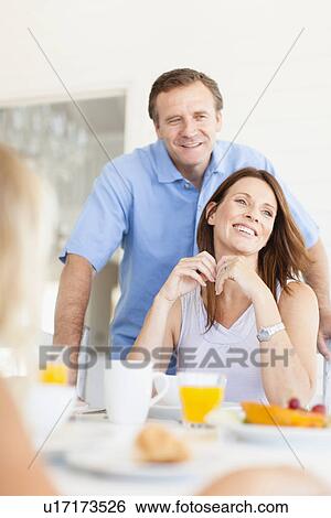 Family eating together at table View Large Photo Image Stock Photograph - Family eating together at table. Fotosearch