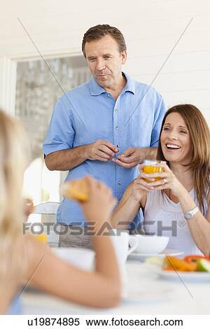 Family eating together at table View Large Photo Image Stock Photography - Family eating together at table. Fotosearch