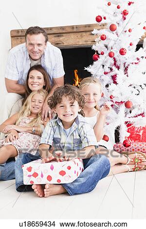 Picture - Family opening Christmas gifts. Fotosearch