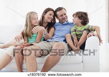 Family relaxing together on sofa View Large Photo Image Stock Image - Family relaxing together on sofa. Fotosearch