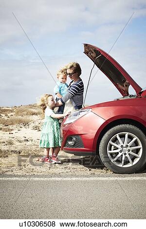 Stock Photo - Family sitting by broken down car. Fotosearch