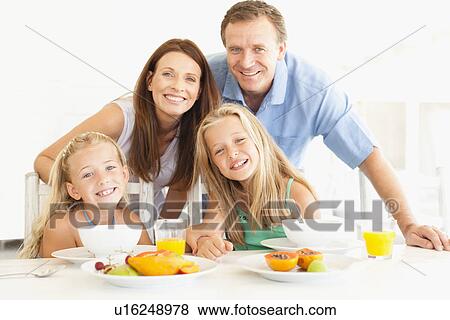 Stock Photo - Family smiling at breakfast table. Fotosearch