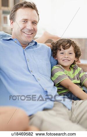 Father and son relaxing on sofa View Large Photo Image Stock Image - Father and son relaxing on sofa. Fotosearch