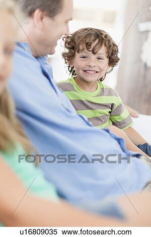 Father and son relaxing on sofa View Large Photo Image Stock Photography - Father and son relaxing on sofa. Fotosearch