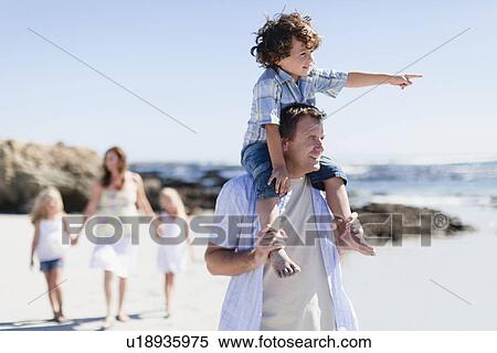 Stock Photography - Father carrying son on shoulders. Fotosearch