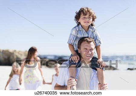 Stock Photography - Father carrying son on shoulders. Fotosearch