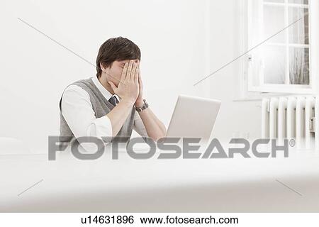 Stock Photograph - Frustrated businessman thinking at desk. Fotosearch