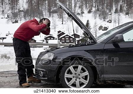 Stock Image - Frustrated man checking car engine. Fotosearch