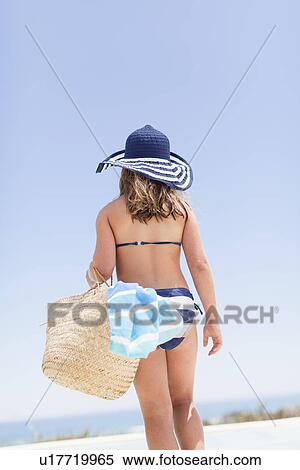 Girl carrying straw bag outdoors View Large Photo Image Stock Photography - Girl carrying straw bag outdoors. Fotosearch