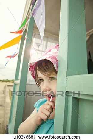 Girl eating lollipop in doorway View Large Photo Image Stock Image - Girl eating lollipop in doorway. Fotosearch
