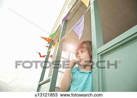 Girl eating lollipop in doorway View Large Photo Image Stock Image - Girl eating lollipop in doorway. Fotosearch