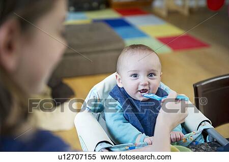 Girl feeding baby brother at table View Large Photo Image Stock Photography - Girl feeding baby brother at table. Fotosearch