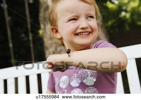 Picture - Girl holding snail on arm. Fotosearch
