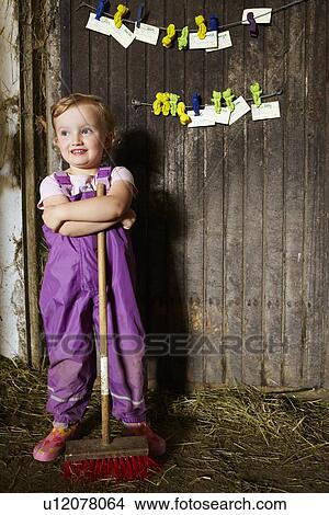 Girl in overalls sweeping in barn View Large Photo Image Picture - Girl in overalls sweeping in barn. Fotosearch