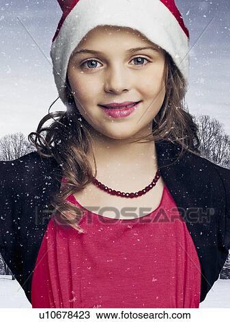 Girl in Santa hat standing in snow View Large Photo Image Stock Image - Girl in Santa hat standing in snow. Fotosearch