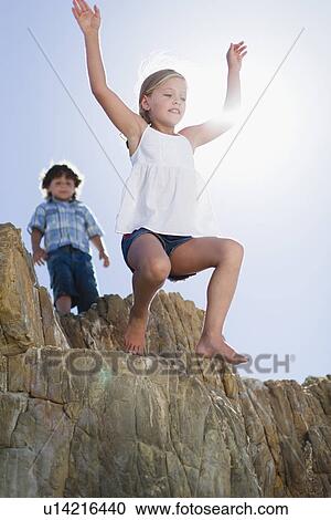 Girl jumping off boulder outdoors View Large Photo Image Stock Image - Girl jumping off boulder outdoors. Fotosearch