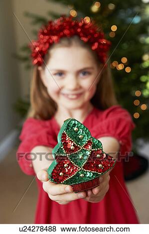 Stock Photo - Girl offering Christmas decoration. Fotosearch