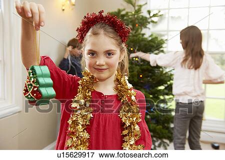 Stock Photo - Girl playing with Christmas decorations. Fotosearch