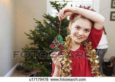 Stock Photo - Girl playing with Christmas decorations. Fotosearch