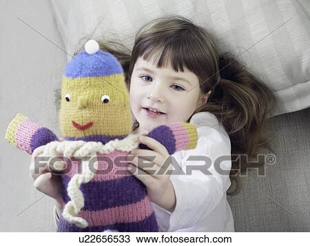 Girl playing with stuffed animal on sofa View Large Photo Image Stock Image - Girl playing with stuffed animal on sofa. Fotosearch