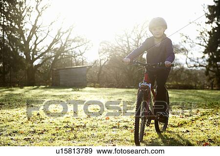 Girl riding bicycle in meadow View Large Photo Image Stock Photo - Girl riding bicycle in meadow. Fotosearch