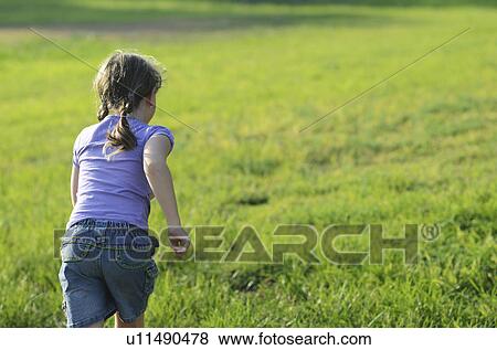 Stock Photo - Girl running in rural meadow. Fotosearch