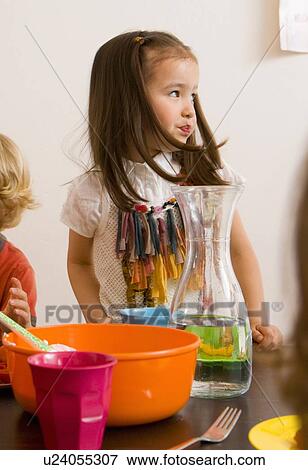 Girl sitting at table in kitchen View Large Photo Image Stock Photo - Girl sitting at table in kitchen. Fotosearch