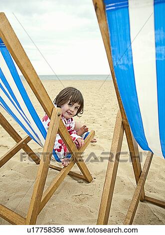 Girl sitting in lawn chair on beach View Large Photo Image Stock Photograph - Girl sitting in lawn chair on beach. Fotosearch