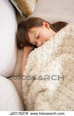 Girl sleeping under blanket on sofa View Large Photo Image Stock Photo - Girl sleeping under blanket on sofa. Fotosearch