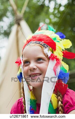 Stock Image - Girl wearing Indian headdress. Fotosearch
