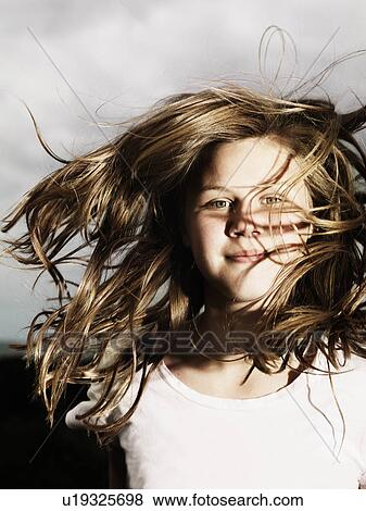 Stock Photo - Girls hair blowing in wind outdoors. Fotosearch