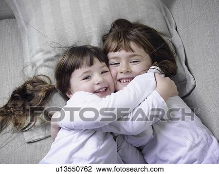 Girls hugging on sofa together View Large Photo Image Stock Image - Girls hugging on sofa together. Fotosearch