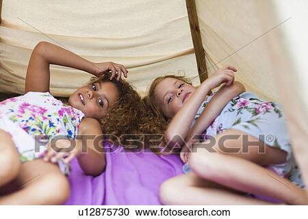 Girls laying together in tent outdoors View Large Photo Image Stock Image - Girls laying together in tent outdoors. Fotosearch