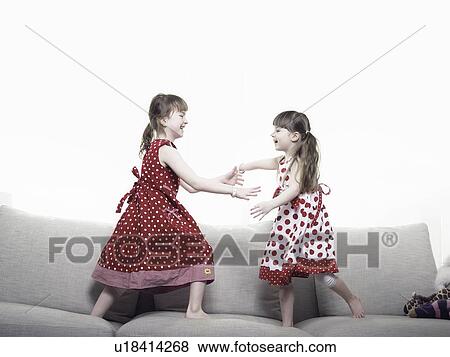 Girls playing together on sofa View Large Photo Image Stock Photo - Girls playing together on sofa. Fotosearch