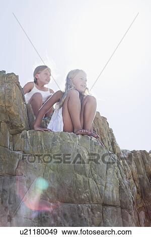 Girls sitting on boulders outdoors View Large Photo Image Stock Photo - Girls sitting on boulders outdoors. Fotosearch
