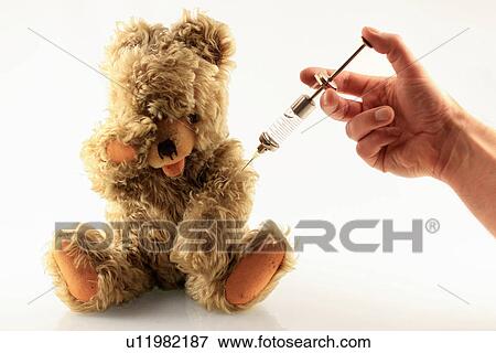 Stock Photo - Hand giving teddy bear a shot. Fotosearch