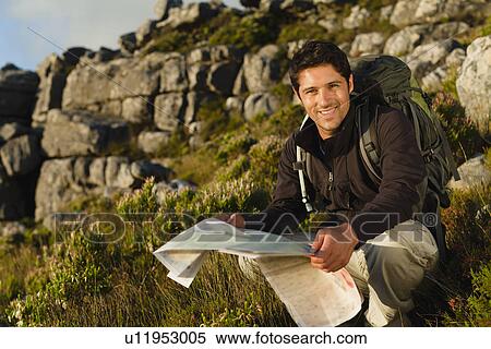 Hiker reading map in rocky field View Large Photo Image Stock Photography - Hiker reading map in rocky field. Fotosearch