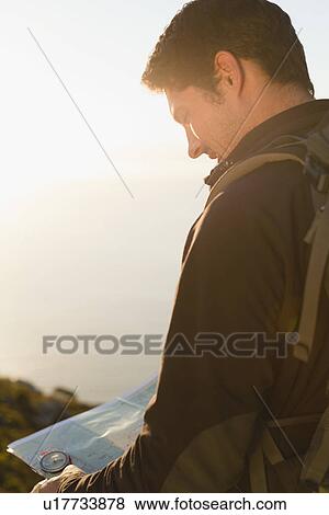 Stock Photo - Hiker reading map outdoors. Fotosearch