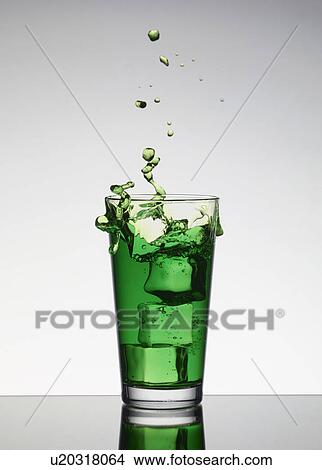 Ice falling into glass of juice View Large Photo Image Picture - Ice falling into glass of juice. Fotosearch