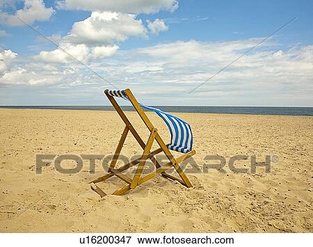 Lawn chair blowing in wind on beach View Large Photo Image Stock Photo - Lawn chair blowing in wind on beach. Fotosearch