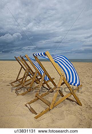Lawn chairs blowing in wind on beach View Large Photo Image Stock Image - Lawn chairs blowing in wind on beach. Fotosearch