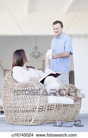 Man bringing girlfriend coffee on porch View Large Photo Image Picture - Man bringing girlfriend coffee on porch. Fotosearch