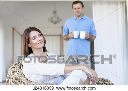 Man bringing girlfriend coffee on porch View Large Photo Image Stock Photo - Man bringing girlfriend coffee on porch. Fotosearch