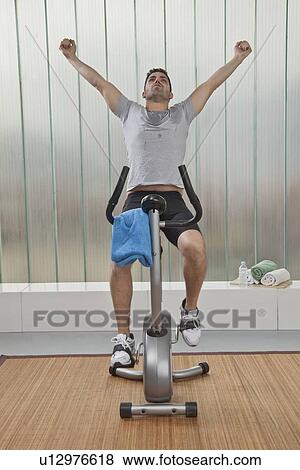 Man cheering on exercise machine View Large Photo Image Stock Photo - Man cheering on exercise machine. Fotosearch
