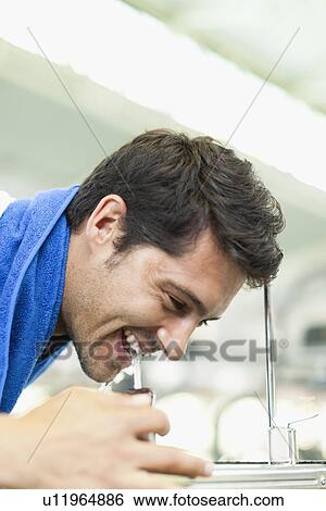 Man drinking from water fountain View Large Photo Image Stock Photograph - Man drinking from water fountain. Fotosearch