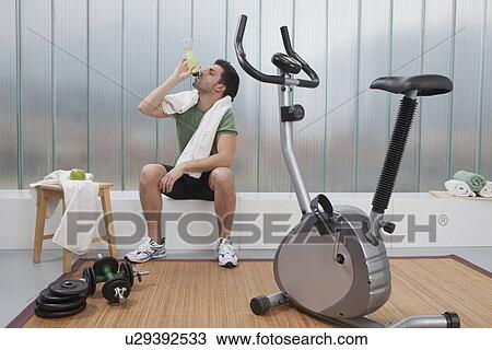 Man drinking sports drink in home gym View Large Photo Image Stock Image - Man drinking sports drink in home gym. Fotosearch