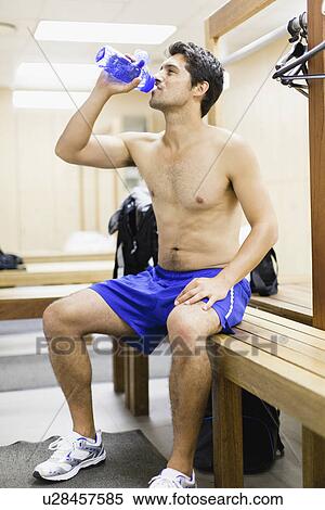 Man drinking water on locker room bench View Large Photo Image Stock Photography - Man drinking water on locker room bench. Fotosearch