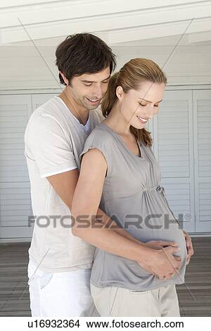 Man holding pregnant girlfriends belly View Large Photo Image Picture - Man holding pregnant girlfriends belly. Fotosearch