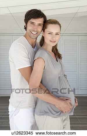 Stock Photography - Man holding pregnant girlfriends belly. Fotosearch